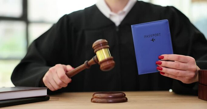 Judge hits gavel on sound block holding international passport in hand. Woman in black mantle puts ban on illegal crossing country border slow motion