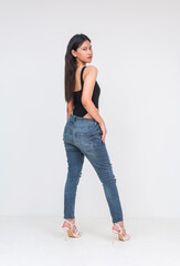 Front view of a sexy young asian woman in a black bodysuit and ripped jeans. Isolated on a white background. Whole body photo.