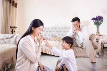 Obraz premium A family of three playing and reading in the living room