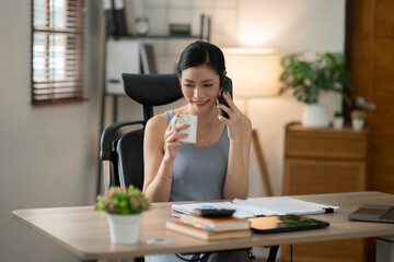 ฺAsia Businesswoman sitting and working using laptop to chat with customers online in office