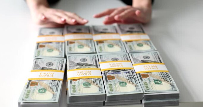 Woman moves away stacks of dollar banknotes on white table making deal with partner. Businesswoman offers money for services. Female refuses to take bribe