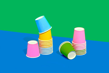 Colorful still life of disposable paper cups on two tone colored background