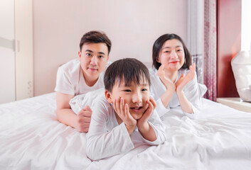 A family of three in the bed in the bedroom