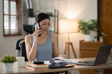 ฺAsia Businesswoman sitting and working using laptop to chat with customers online in office