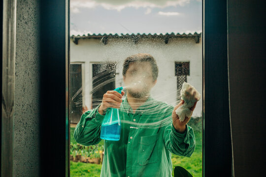 Man cleaning window with soap solution