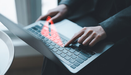 Businessman or programmer, developer using computer laptop with triangle caution warning sign for...