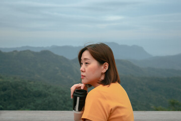 solo asian woman hipster traveler drink coffee at mountain view of outdoor bar of coffeeshop