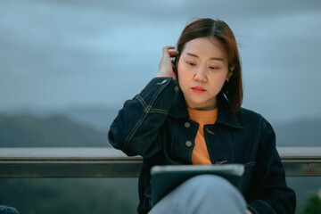 asian woman use tablet for stock and cryptocurrency trading from outdoor of coffee shop