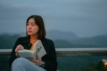 asian woman read and relax from outdoor of coffee shop