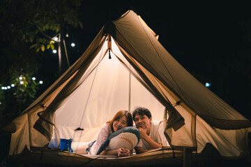 asian couple relax in camping tent on summer vacation