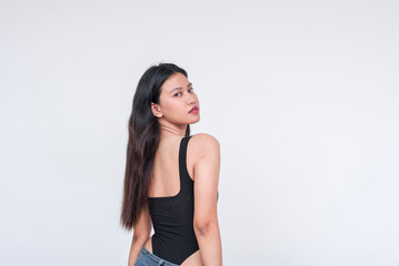 Young Asian woman in black bodysuit posing elegantly on a white background