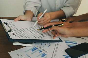 Fototapeta premium In an office, a woman and a man work together at a desk, using teamwork and communication to succeed in their business meeting.