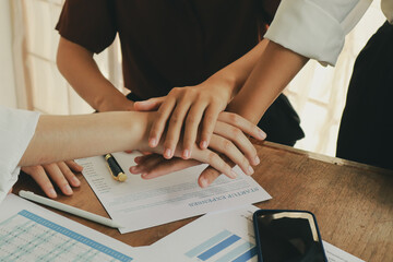 In an office, a woman and a man work together at a desk, using teamwork and communication to succeed in their business meeting.