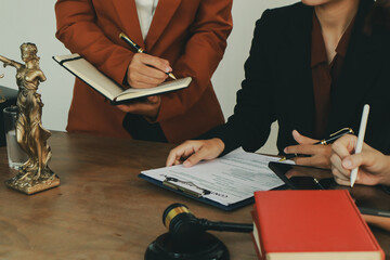 A lawyer prepares for a meeting at their desk, gathering documents and notes. They discuss legal...