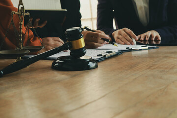 A lawyer prepares for a meeting at their desk, gathering documents and notes. They discuss legal matters, offering guidance and expertise to clients.