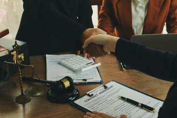 A lawyer prepares for a meeting at their desk, gathering documents and notes. They discuss legal...