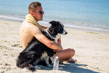 relaxed young man with his dog on the beach