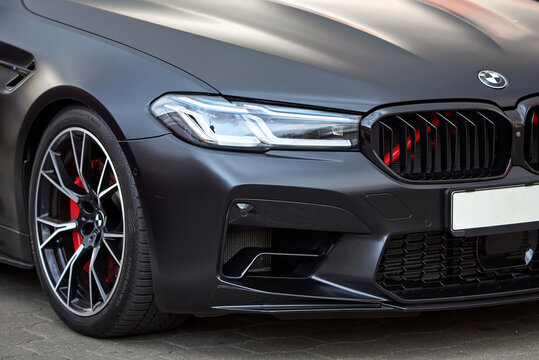 Minsk, Belarus. Apr 2, 2024. BMW M5 F90 Competition at the parking lot. LED adaptive headlights and dynamic grille of Satin Black BMW M5 F90. Front body exterior closeup.