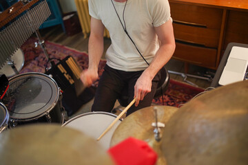 High angle view closeup of young male drummer's hands playing in home studio motion blur and...