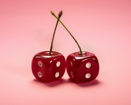 Cherries in the form of a dice isolated on a red background.