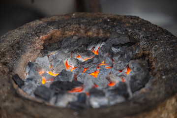 Burning coal on mud stove or chulha at tea shop.