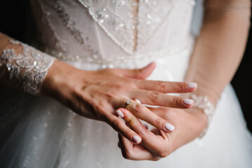 Bride puts a wedding ring on finger. Closeup of hands of a woman showing the elegant diamond ring on the finger, love, and wedding concept. Engagement. Soft and selective focus.