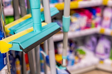 Window cleaning tools, window squeegee, in the store. Housekeeping products, cleaning tools  on the shelf defocused.