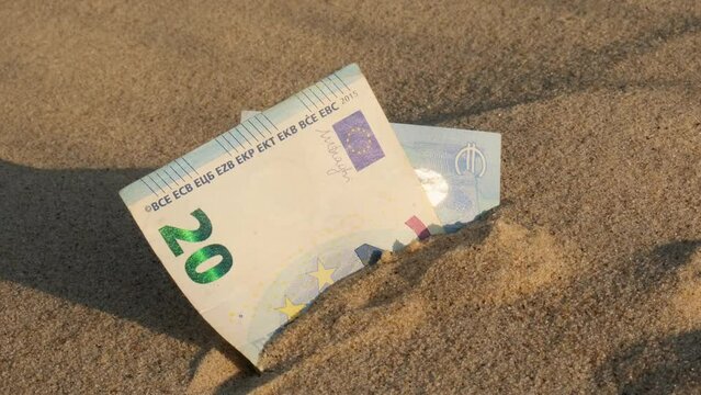 Money 20 euros bills in sandy beach. Concept finance saving money for holiday vacation. Costs in travel holidays. Shadows
