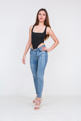 Young Asian woman in black bodysuit and jeans standing confidently