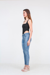 Young Asian woman in black bodysuit and jeans standing isolated on white background