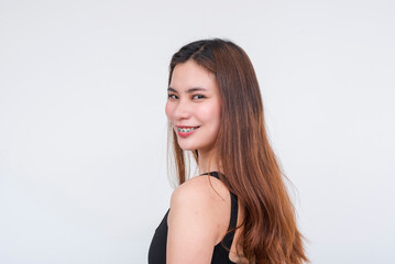 Smiling young Asian woman in a black bodysuit, isolated on a white background