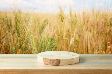 Empty wooden log on table over wheat field background. Jewish holiday Shavuot mock up for design...