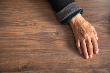 Elderly female hand on the table.