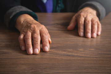 Elderly female hand on the table.