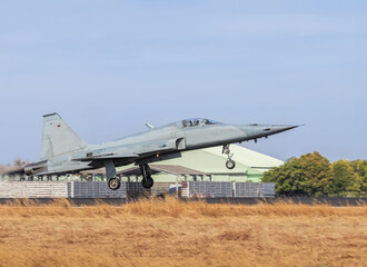 Fighter jet military flying with high speed take off  from runway with blue sky