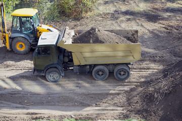 A truck with soil at the construction site, cleaning up the excavated ground at the construction site, a truck with soil at the construction site