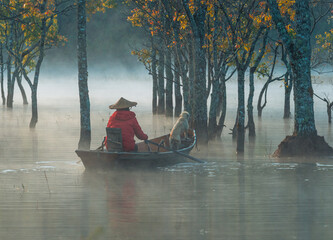 Foggy morning on the stream and the old man on the boat and the dog on the Tia stream, Da Lat....