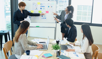 Asian group of people working with documents have financial or marketing charts on a board room...