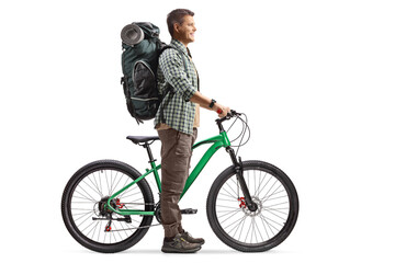 Full length profile shot of a man with a backpack standing with a bicycle