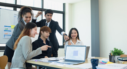 Asian group of people working with documents have financial or marketing charts on a board room table at a business presentation or seminar.