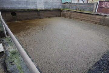 A cement pool is filled with mud and dirt