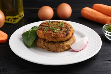 Vegetarian product. Tasty carrot cutlets served on black wooden table