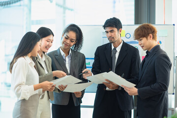 Business team in a meeting, Asian group of people working with documents have financial or marketing charts on a board room table at a business presentation or seminar.