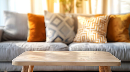 Wooden coffee table in sharp focus with a cozy sofa adorned with decorative pillows in the background