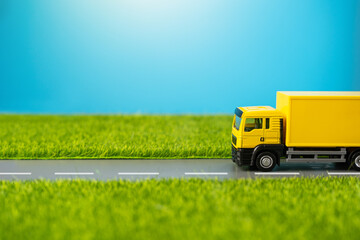A truck drives along a country road through green meadows. Delivery of online orders and purchases....