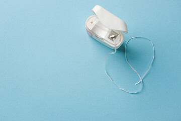 Top view of dental floss in white box on blue background