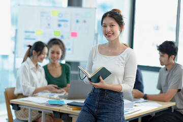 Asia young creative woman in smart casual wear looking at camera in office workplace.