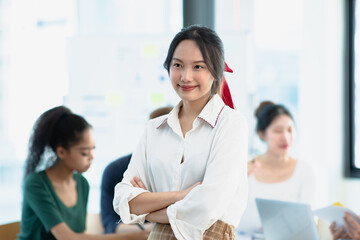 Fototapeta premium Asia young creative people in smart casual wear looking at camera in office workplace.
