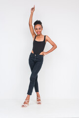 Cheerful young woman of mixed African and Asian ancestry posing in black bodysuit