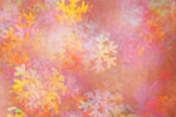 Fototapeta na wymiar Defocused abstract figured bokeh background, glare from lights as snowflakes, blurred snowflake bokeh as winter holiday texture. Creative New Year aesthetic textured lighting pattern for festive